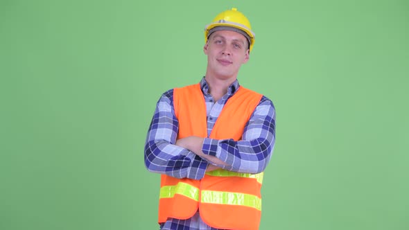 Happy Young Man Construction Worker Smiling with Arms Crossed