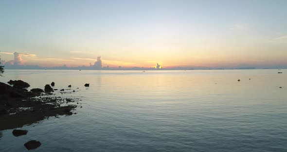 Sunrise Thailand Aerial Silhouette Woman Rise Up Hands Stays on Rocky Beach Near Serene Water