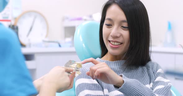 Woman dentist working at her patients teeth