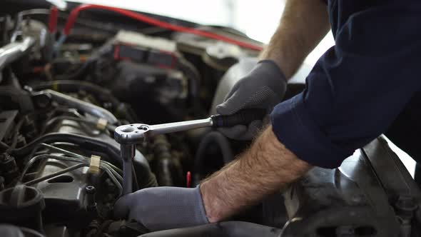 Car Mechanic Using Wrench to Repair the Engine in a Car Service Close Up