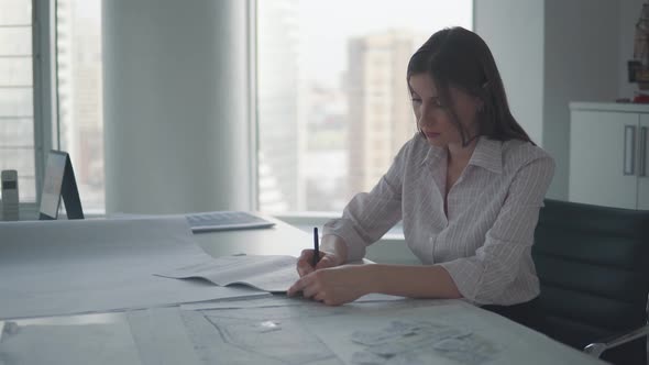 Office Worker Works with Documents and Drawings in the Office