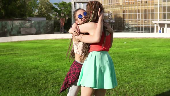 Two Happy Young Girls with Dreads Hugging Each Other