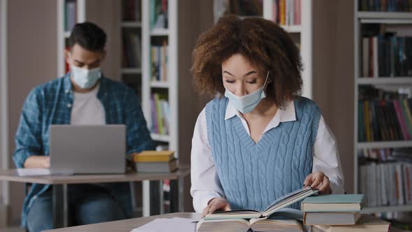 Two Students in Medical Masks Studying Preparing for Exam in University Library Young Guy Working