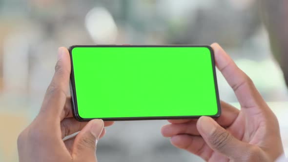 Holding Horizontal Smartphone with Green Chrome Key Screen