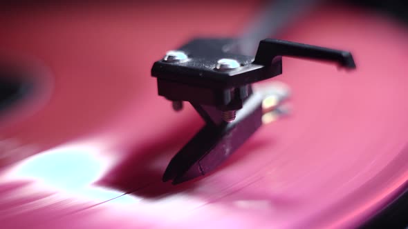 vinyl player. pink plate. Black background. macro. vinyl pickup