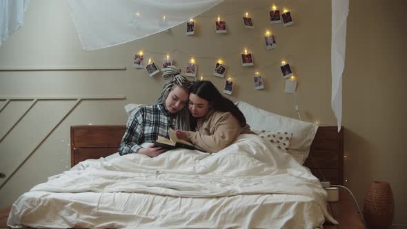 Girlfriends Laying in Bed and Reading Book