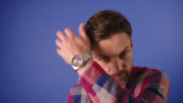 Portrait Shot of a Young Bearded Caucasian Man Adjusting Hear in Front of the Camera Like a Mirror