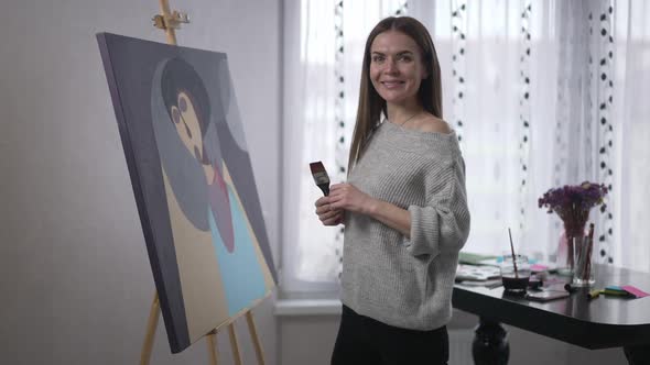 Portrait of Young Woman Smiling Looking at Camera Painting Abstract Picture with Brush Making