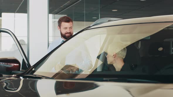 Happy Middleaged Slender Blonde Businesswoman Sitting Inside a Modern Car While