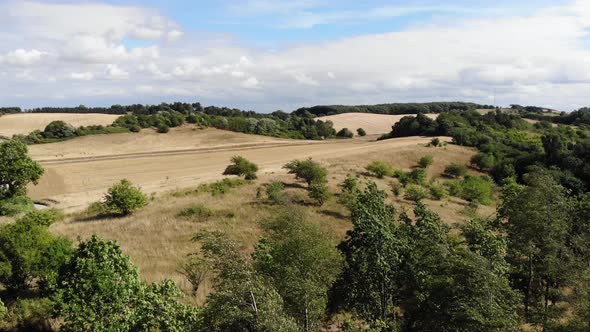 Aerial view of the coastline of Sejerøbugten with hills and trees.