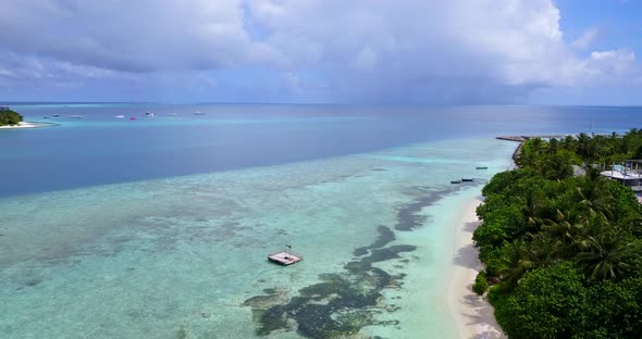 Daytime overhead island view of a white paradise beach and aqua turquoise water background