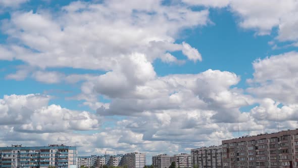 Cumulus Cirrus Clouds Move in the Blue Sky Over Multi-story Buildings in City