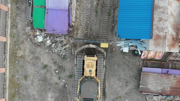 Top Aerial View on Tracked Bulldozer Rides on Sandy Road at Construction Site