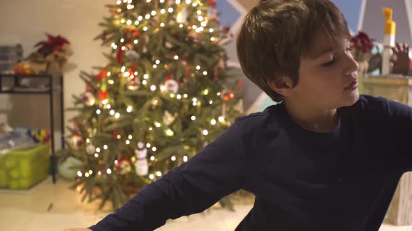 Caucasian boy decorating homemade gingerbread cookies with sugar icing, using a piping pastry bag, b