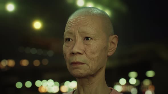 Old Asian Woman in City at Night alt