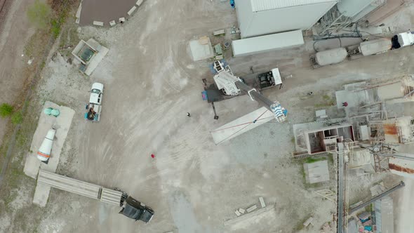 Aerial Drone View of Crane Unloads the Carrier's Truck at the Factory