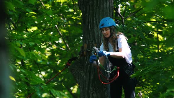 Rope Adventure - a Woman Attaching the Hook To the Insurance Rope on the Tree