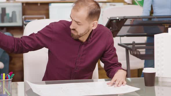 Bearded Young Architect Drawing the Project of a Building