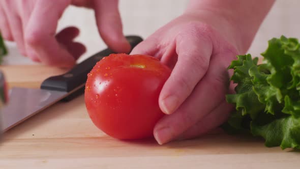 Slicing fresh tomatoes, closeup