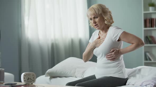 Pretty Mature Woman Sitting on Bed and Suffering From Heart Attack, Health