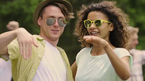 Happy Male and Female Friends Having Fun at Summer Party, Waving Hands to Music