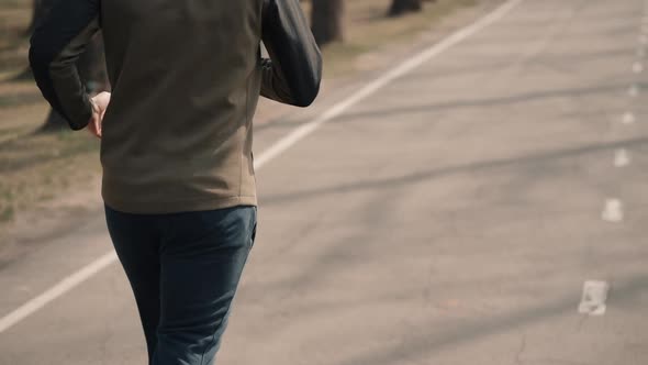 Back View Man Running in Spring Park. Male Jogger in Tracksuit Test His Endurance. Jog in Morning