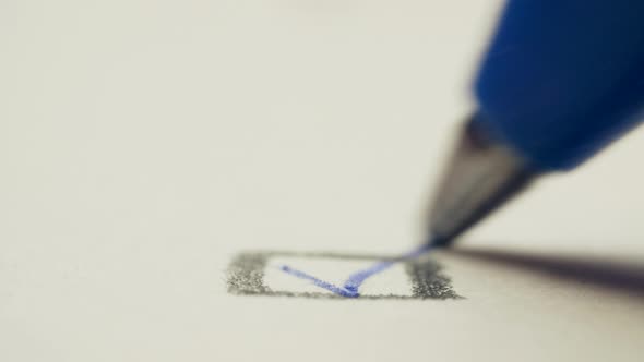 Pen Draws a Check Mark on a White Background Paper, Macro Shot