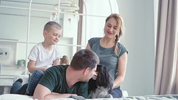 Loving Family and Little Son a Boy of European Appearance Sitting on a Bed in a Cozy Modern Room