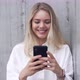 Smiling Woman Using Smartphone Near Wall - VideoHive Item for Sale