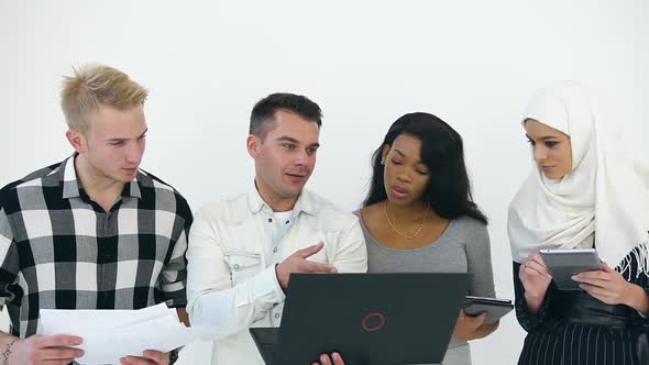 Multiethnic Corporate Coworkers Working with Computer, Tablet pc and Financial Reports