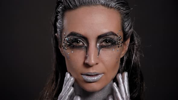 A Female Model with Silver Body Art on Her Body Poses in the Studio