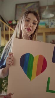 Two Attractive Young Girls are Standing in the Studio with Lgbt Posters in Their Hands and Looking