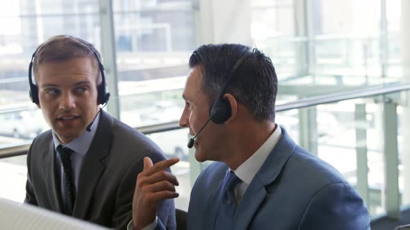 Businessmen wearing headsets in a modern office