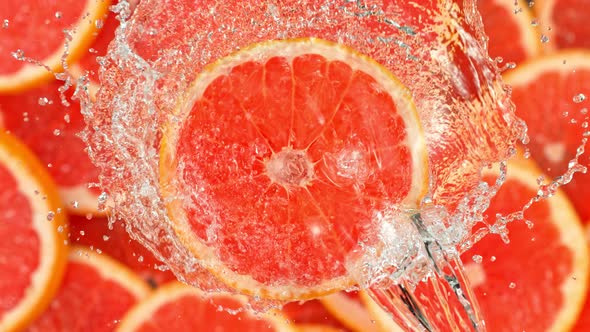 Super Slow Motion Shot of Splashing Water on Rotating Grapefruit Slice at 1000Fps.