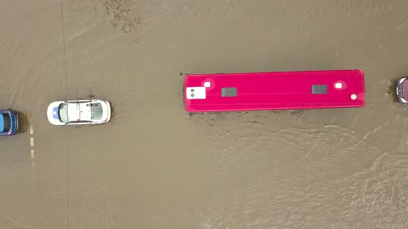 Aerial view of traffic cars driving on flooded road with rain water.
