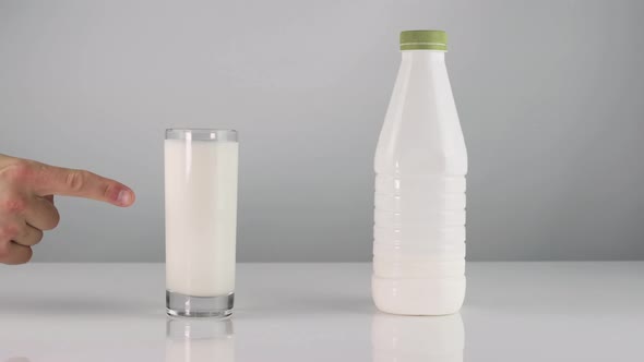 Glass Of Milk On A White Background. Kefir White Yogurt. The Guy Shows A Finger To Drink