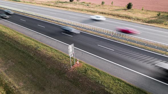 Aerial Drone Hyper Lapse Footage of Cars Moving Fast on Busy Highway or Motorway at Sunset