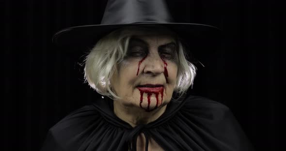 Old Witch Halloween Makeup. Elderly Woman Portrait with Blood on Her Face