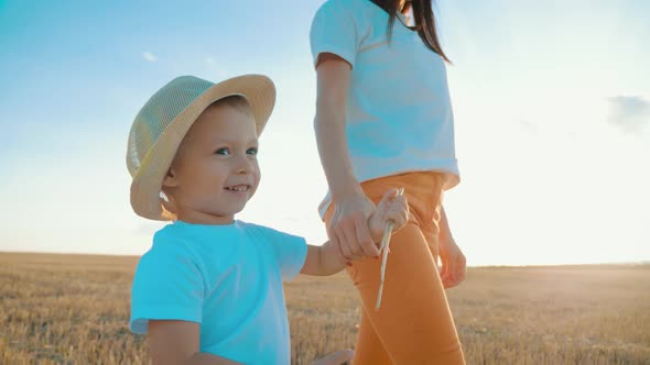 Mother and Little Son Holding Hands Into the Sunset. Child Have a Trust for Mother, Family Concept