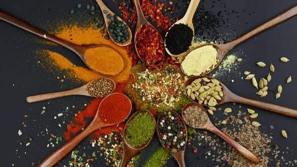 Dry Colorful Spices in Spoons and Bowls with Fresh Seasoning on Dark Background Top View