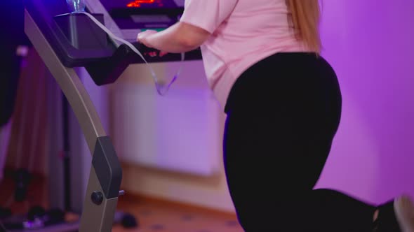 Unrecognizable Obese Caucasian Woman Running on Treadmill Indoors