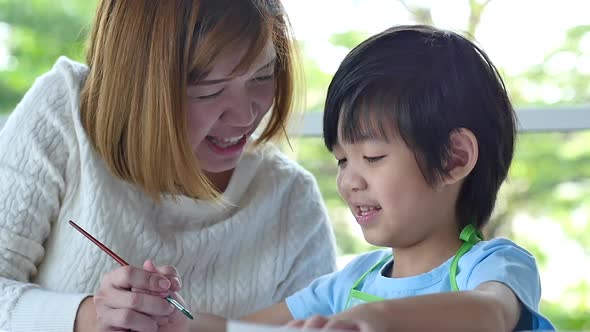 Cute Asian Child And Mother Painting Together