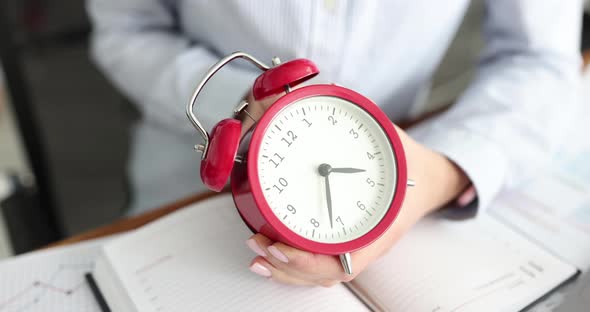 Businesswoman Translates Red Alarm Clock Back at Workplace