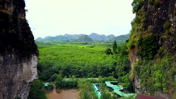 Aerial Shot Passing Through Mountains Into Palm Trees Field Krabi Thailand