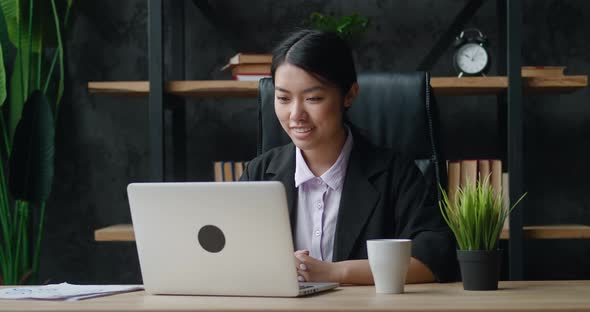 Asian Business Woman Video Chatting with Laptop at Office