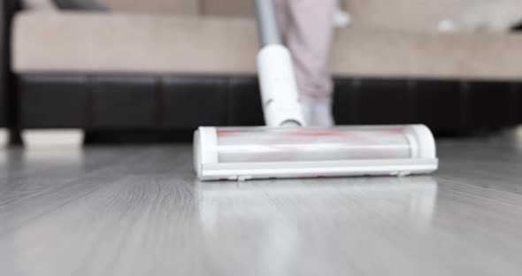 Woman Cleaning Lady Vacuums Floor in Living Room Closeup