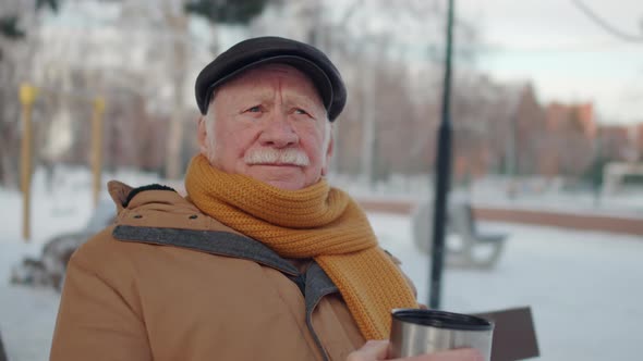 Senior Man Drinking Hot Tea in Park