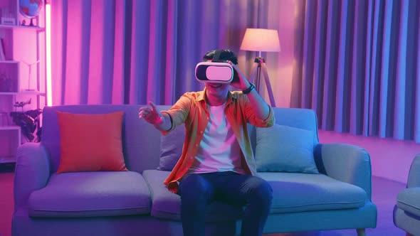 Young Asian Man Explores Virtual Reality At Living Room, Cyan And Magenta Colours