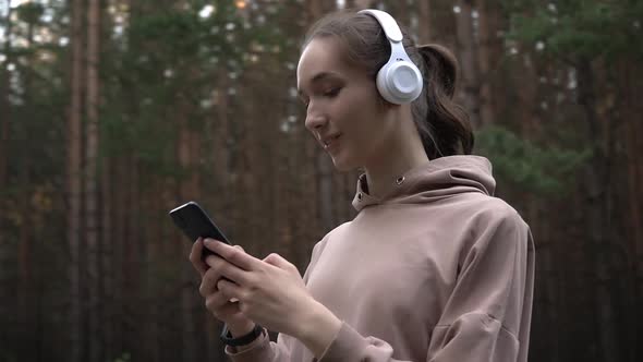 A Girl with Headphones and a Smartphone on a Jog