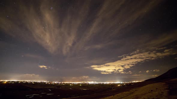 Time lapse of the nights sky over city lights as stars move overhead